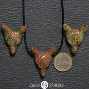 Drei Unakit Wolf Anhänger nebeneinander. Einer befindet sich an einem schwarzen Baumwollband.